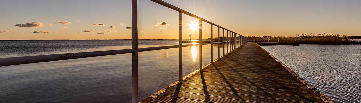 Holzsteg Sonnenuntergang ruhiges Gewässer Wolken blauer Himmel Insel Usedom