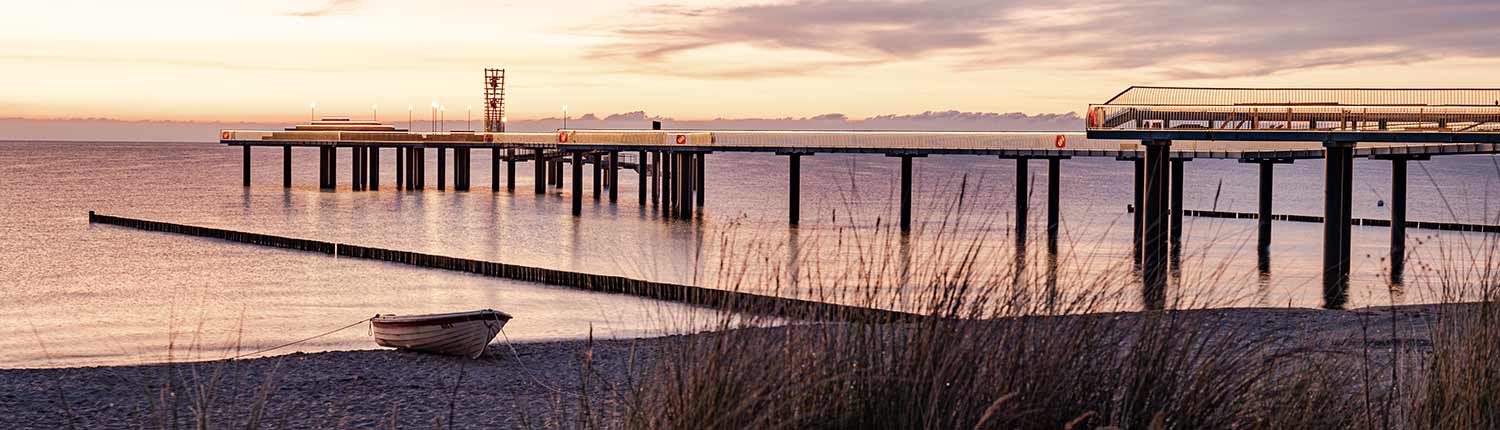 Seebrücke Koserow Sonnenuntergang ruhige Ostsee Meer oranger Himmel Wellenbrecher Insel Usedom Boot Sand Schilf