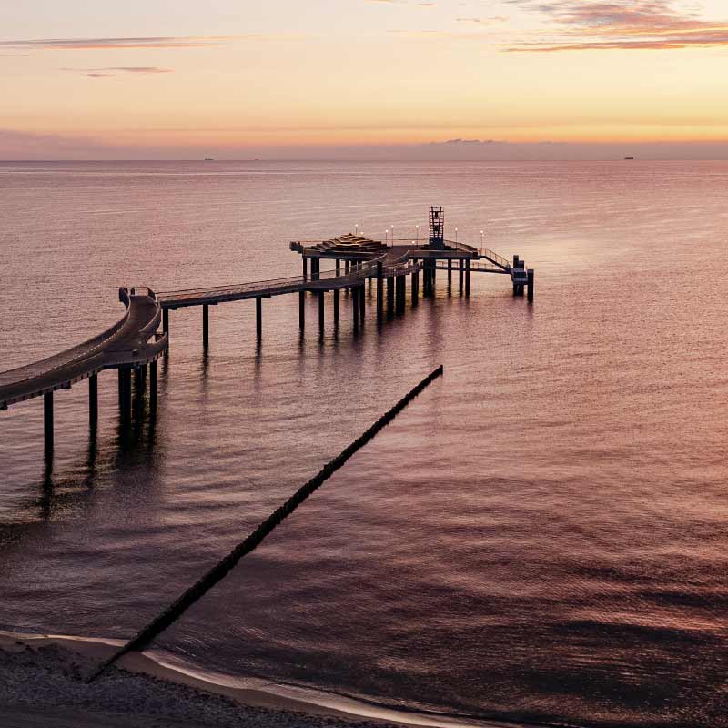 Seebrücke Koserow Sonnenuntergang ruhige Ostsee Meer oranger Himmel Wellenbrecher Insel Usedom